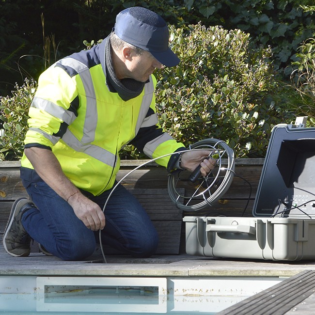 Technicien AGM TEC en inspection horizontale au bord d’une piscine, mallette et jonc Tubicam.